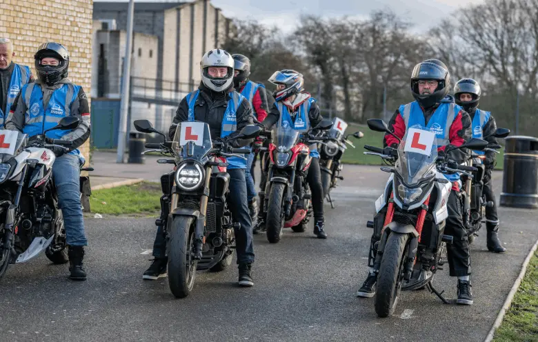 A row of learner riders in blue Bikes in Motion student vests, sitting on motorbikes with L plates ready to start a training session.